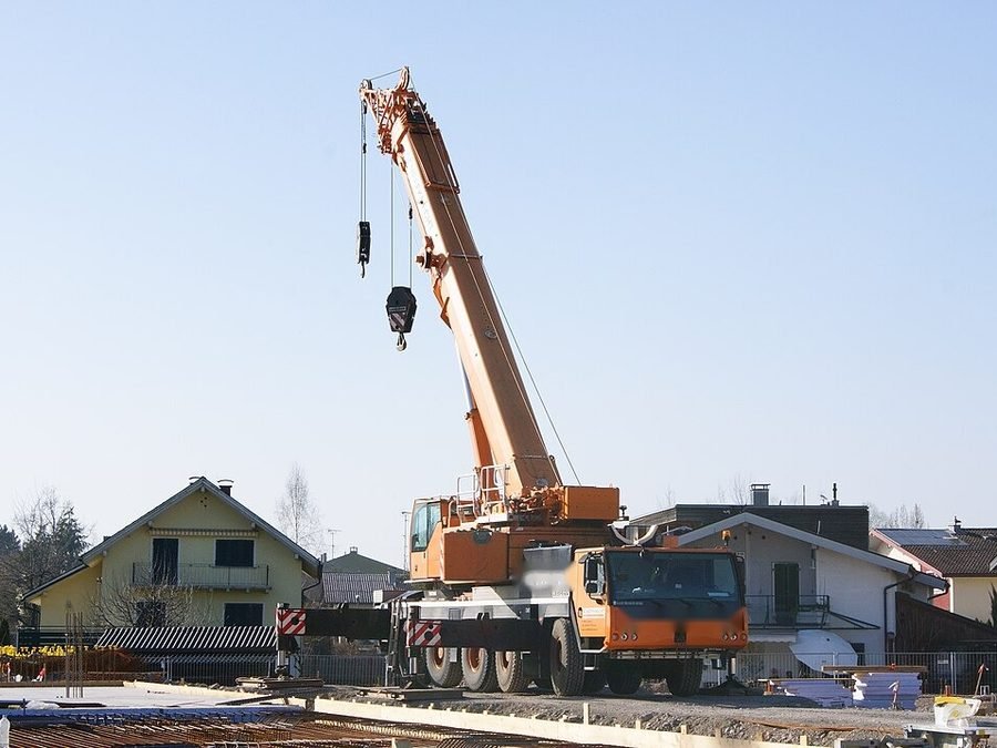Grue mobile télescopique en levage au milieu de maisons individuelles