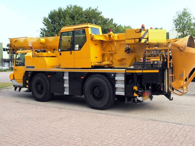 Grue mobile Liebherr à deux essieux vue de trois quarts arrière, avec benne à béton