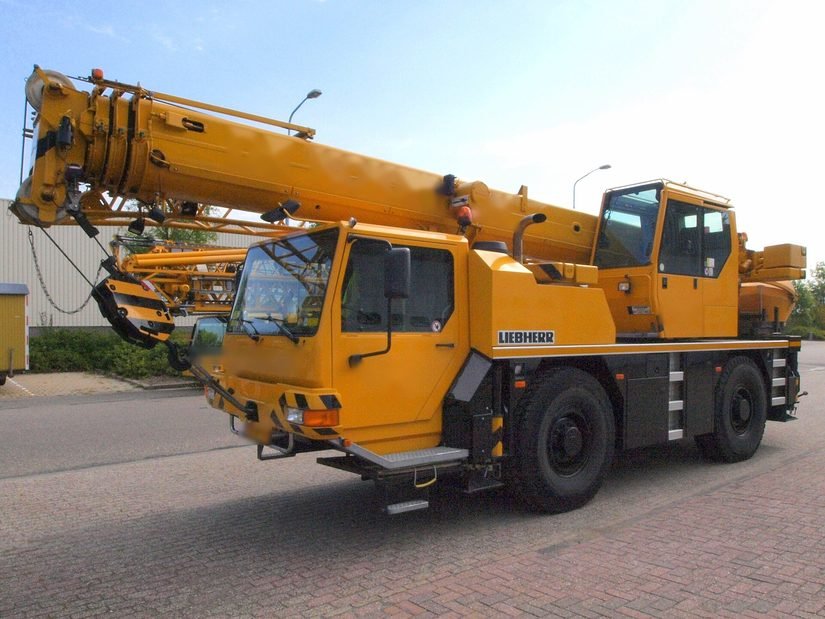Grue mobile Liebherr LTM 1030-2.1 jaune, flèche repliée, vue de trois quarts avant